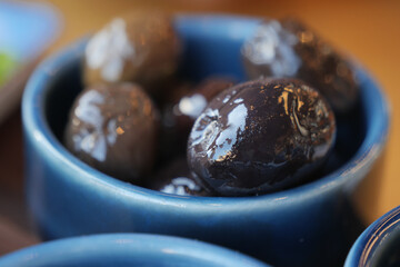 Delicious black olives served in a blue bowl at a culinary event