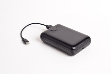 Fully charged portable power bank with cable isolated on white background. External battery for mobile devices
