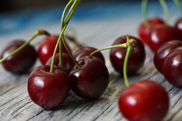 Tasty fresh red cherries incite longings for summer and biting into the juicy fruit. With the stems still attached, these cherries have only just made their way from the farm to the market, a jackpot 