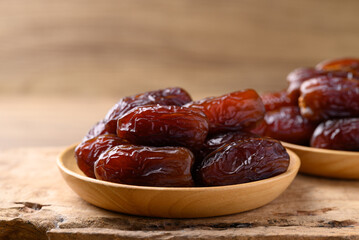 Date palm fruit (MedJool) on wooden plate