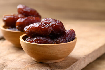Date palm fruit (MedJool) in wooden bowl, Tropical fruit