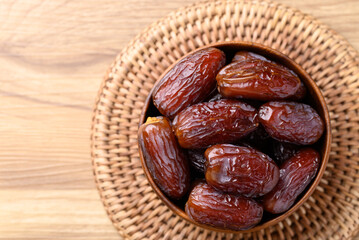 Date palm fruit (MedJool) in wooden bowl, Table top view