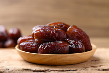 Date palm fruit (MedJool) on wooden plate