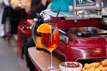 Aperol Spritz on A Sideboard in a Busy Market 