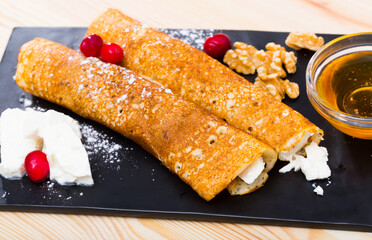 Appetizing pancakes stuffed with young cheese and honey