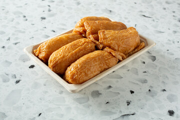 A view of a tray of inari sushi.