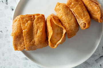 A top down view of a plate of inari sushi.