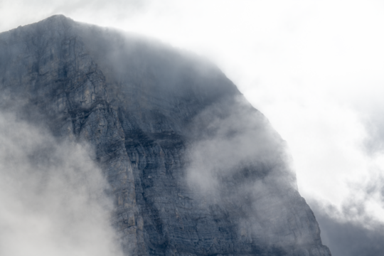 Rocky mountain slope covered in mist with large area of transparent sky
