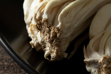 A closeup view of the bottom portion of enoki mushrooms.