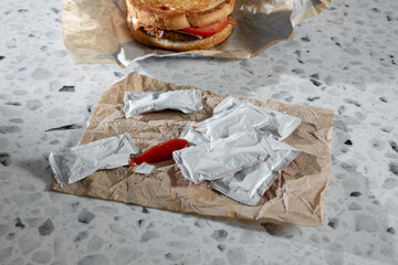 A view of a pile of restaurant style ketchup packets.