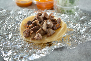 A view of a street taco featuring lengua meat.