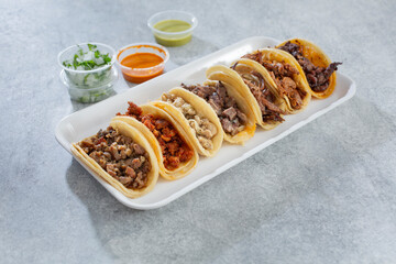 A view of a variety of street tacos on trays.