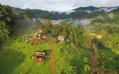 Aerial view from drone of the rural village in the mountains on foggy day