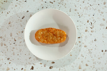 A top down view of a hash brown on a plate.