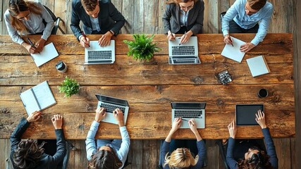 Overhead View: A modern business meeting captured from an elevated perspective, showcasing individuals engrossed in collaborative work.