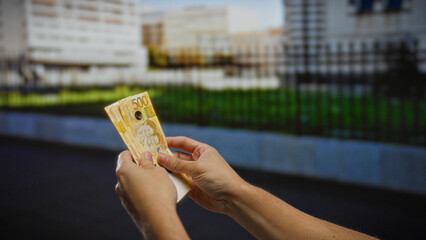 Hands holding philippine pesos in an urban setting, suggesting a business transaction or investment opportunity amid the bustling city life of the philippines.