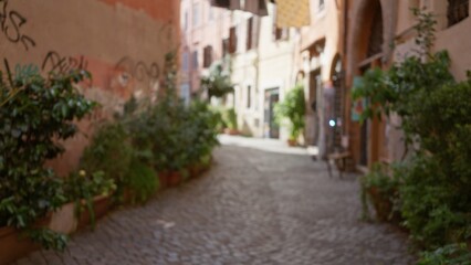 Fototapeta premium Blurred view of a charming old town street in rome, italy with rustic buildings, cobblestones, and lush greenery creating a serene and timeless outdoor ambiance.