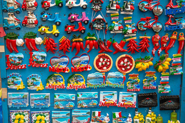 Traditional souvenirs of Naples in a shop, including ceramics, magnets, and local crafts