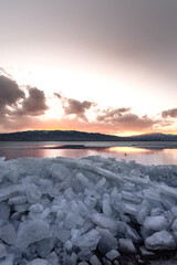 Fire and Ice. Ice stacks in foreground and bright orange sunset over Utah Lake.