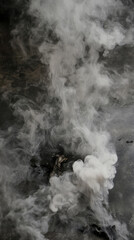 swirling cloud of smoke rises from dark surface