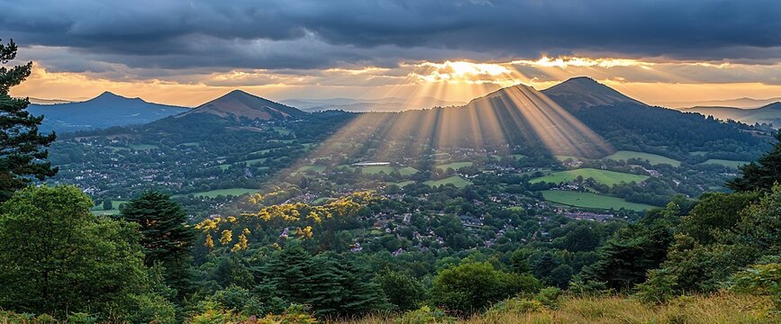 Sunset rays over Malvern Hills town, UK. Peaceful landscape, nature background