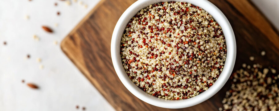 Close up of cooked mixed quinoa in white bowl on wooden board, showcasing its texture and colors, perfect for healthy meal ideas