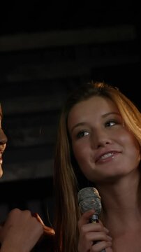 Happy friends singing songs together in a bar