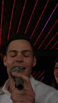 Happy friends singing songs together in bar