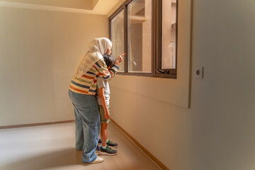 A mother and her two children are viewing an empty apartment, symbolizing the concept of searching...