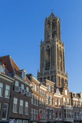 Dom tower in Utrecht surrounded by historic buildings and a blue sky. Domtoren illuminated at the...