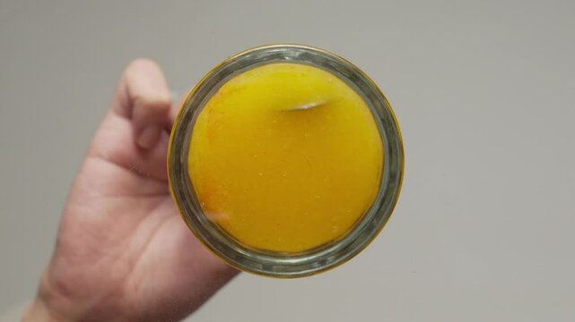 Human Hand Stirring Powdered Juice Drink In A Glass. Close-up Shot