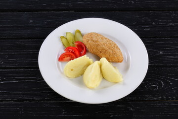 mashed potatoes with cutlet and vegetables on a plate