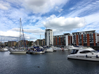 High-rise residential buildings against the backdrop of numerous ships and boats in the city harbor
