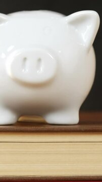 Close-up of books stack with piggy bank