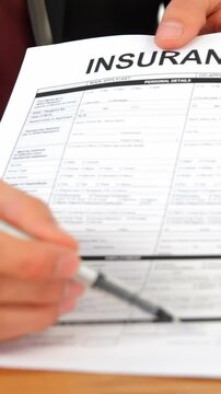 Mid section of businessman sitting at desk holding insurance contract