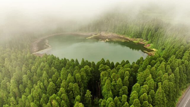 Aerial approach tilt-down as fog moves over Lagoa do Can&aacute;rio, Sete Cidades