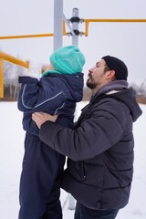 A father and son enjoy a fun winter activity outdoors, tubing down a snowy hill. The photo captures their joyful smiles, bonding moments, and the excitement of a thrilling winter sport