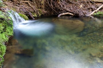 waterfall in a crystal clear river silk effect long exposure photography