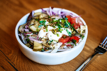 Salad bowl on wooden table background. Delicious healthy vegetable salad made from eco products