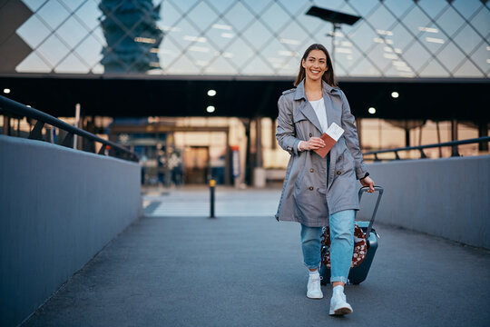 Full length of happy woman arriving at airport.