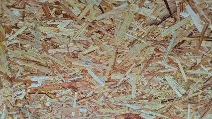 Chipboard. Close-up of the surface of recycled pressed wood chips. Theme of building materials. Wooden background.