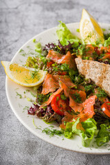 Salad with smoked salmon on stone table. Healthy eating concept