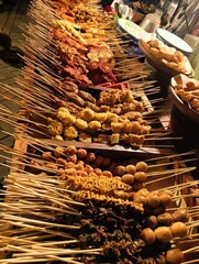 Food stall full of skewers variety at angkringan, traditional food hawker