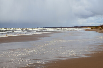 
you can see a wide beach with foam formed by the waves of the sea.