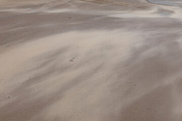 
you can see a sand dune embankment with people and cars on it.
