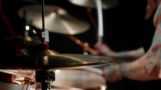 Playing rock music, closeup view of drum set and drumsticks in hands of musician . Details of musical instruments, cool rock band performing in contemporary concert hall, professional musician playing