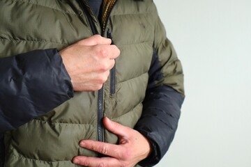 man zipping up winter jacket