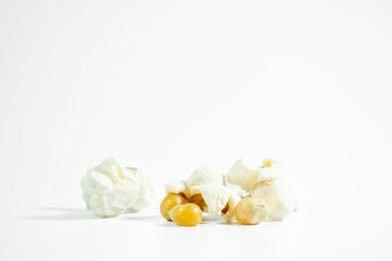 Popcorn. Popped and unpopped popcorn on white background. Ground level horizontal photo. Copy space, blank empty. 
