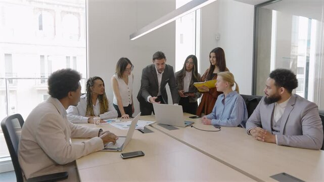 Busy corporate office, diverse business professionals team is discussing financial analysis, reviewing sales reports, brainstorming innovative strategies for success in their operations and projects