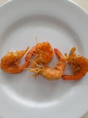 A simple presentation of crispy fried shrimp on a plain white plate